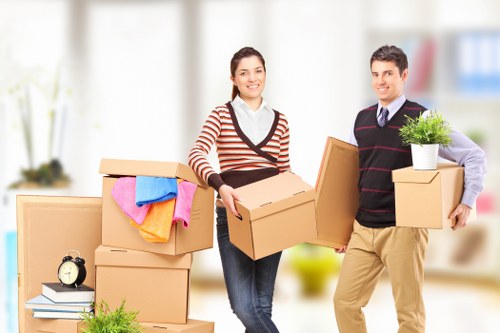 Mover navigating a West Kensington flat staircase with furniture