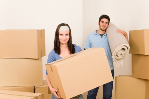 Removal professionals transporting desks and equipment through a commercial property